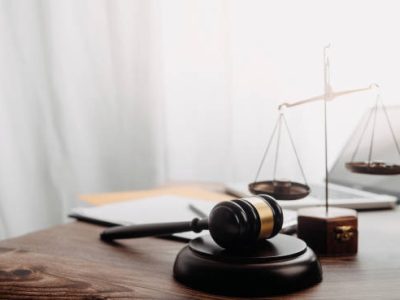 Business and lawyers discussing contract papers with brass scale on desk in office. Law, legal services, advice, justice and law concept picture with film grain effect